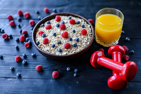 Healthy breakfast: oatmeal with berries and a glass of fresh jui