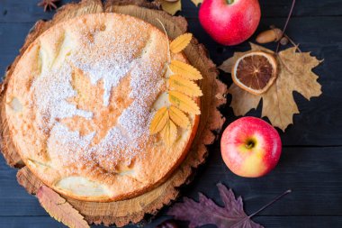 Ahşap koyu bir masada ev yapımı elmalı turta, üst görünüm.