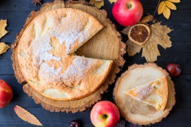 Ahşap koyu bir masada ev yapımı elmalı turta, üst görünüm.