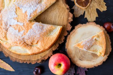 Ahşap koyu bir masada ev yapımı elmalı turta, üst görünüm.