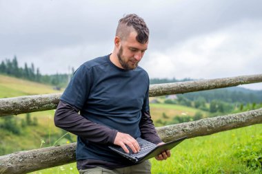 Freelancer açık havada bir dizüstü bilgisayar üzerinde çalışıyor.