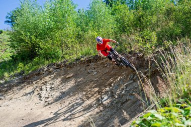 Kayalık arazide dağ bisikletine binen bisikletçi.