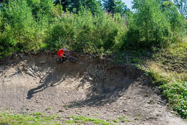 Ciclista montando una bicicleta de montaña en terreno rocoso . — Foto de Stock