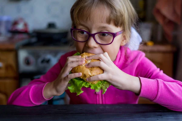 Girl bites a homemade burger.
