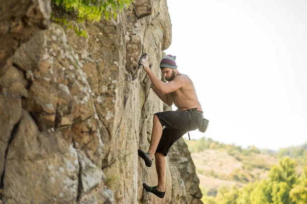 Hombre escalador subiendo a la cima de la roca . —  Fotos de Stock