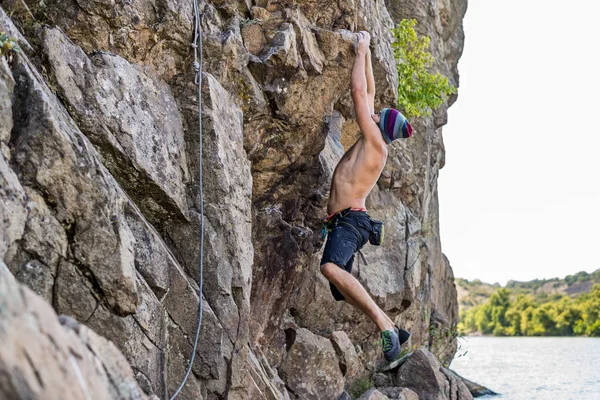 Arrampicante uomo in cima alla roccia . — Foto Stock