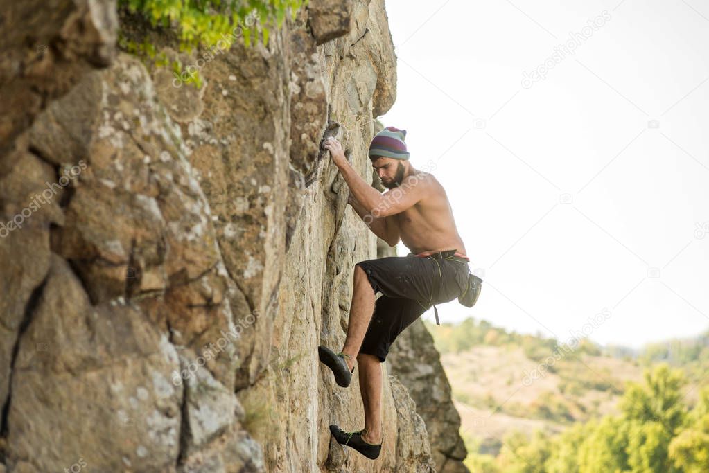 Man climber climbing to the top of the rock.