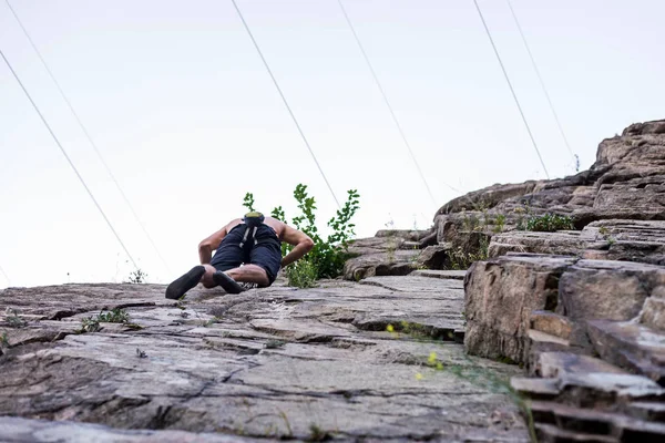 Hombre acantilado escalador está escalando una roca . — Foto de Stock