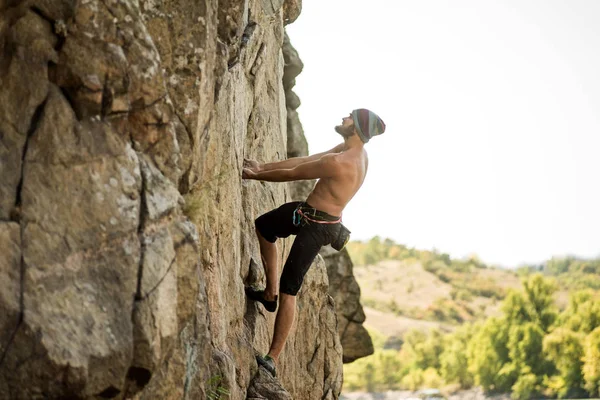 Hombre acantilado escalador está escalando una roca . —  Fotos de Stock