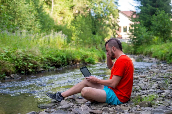 Man arbetar utomhus med en bärbar dator, kopiera ledigt utrymme. — Stockfoto