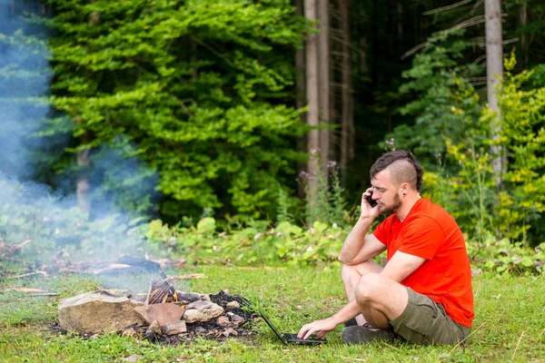 Concept de travail à distance : un homme travaillant sur un ordinateur portable à l'extérieur. Travailler pendant les vacances, bourreau de travail. Freelance — Photo