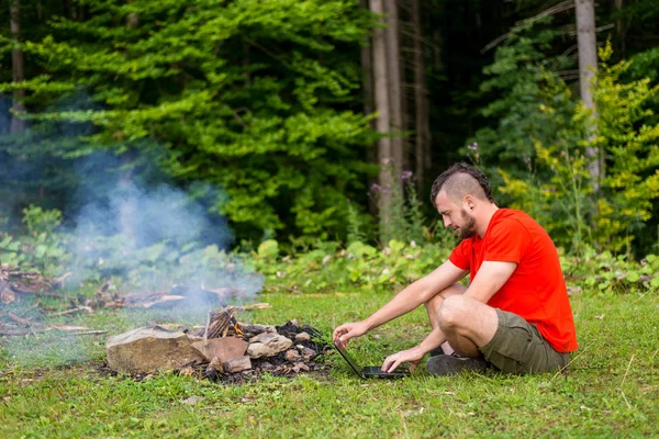 Concept de travail à distance : un homme travaillant sur un ordinateur portable à l'extérieur. Travailler pendant les vacances, bourreau de travail. Freelance — Photo