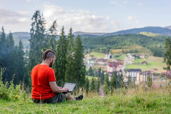 Concetto di lavoro a distanza: un uomo che lavora su un computer portatile all'aperto. Lavoro durante le vacanze, maniaco del lavoro. Freelance — Foto Stock