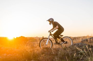 Güzel günbatımında, yokuş aşağı aşırı dağ bisikleti.