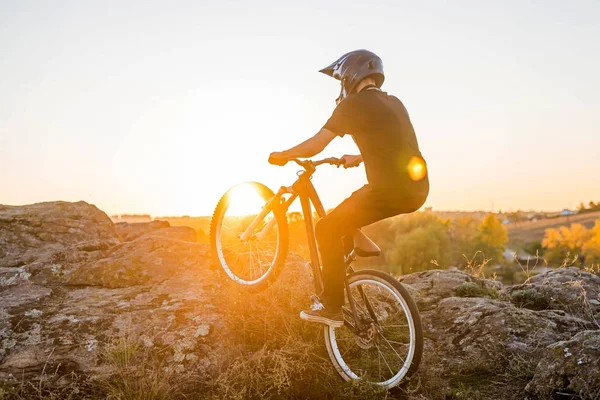 Ciclista montando la bicicleta de montaña en la hermosa puesta del sol . — Foto de Stock