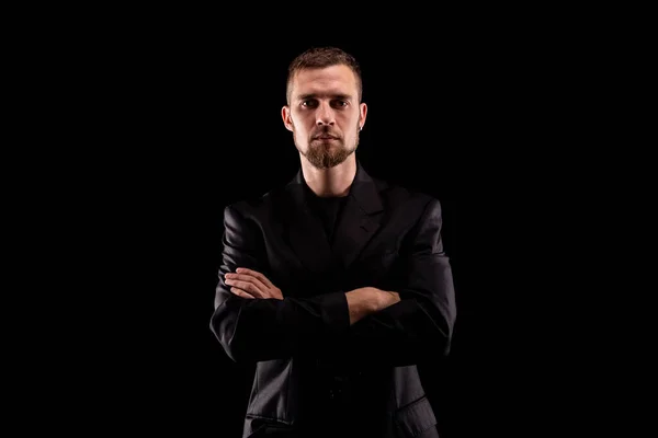 Portrait of a business man in black suit isolated on black background. Business stylish portrait.