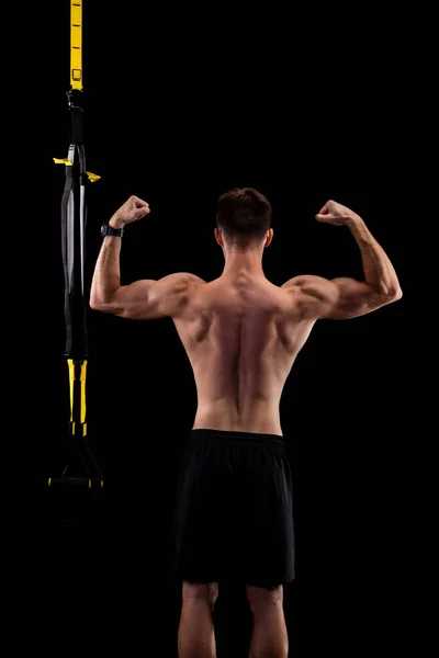 黒の背景に孤立したTrxループを持つ若い筋肉の男 バックビュー スポーツ アクティブライフスタイル — ストック写真