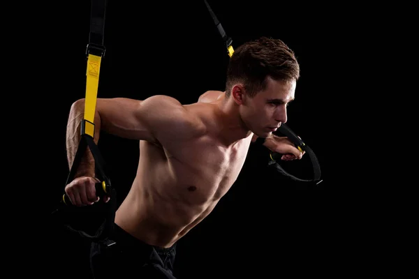 Junger Muskulöser Mann Der Mit Trageschlaufen Auf Schwarzem Hintergrund Trainiert — Stockfoto