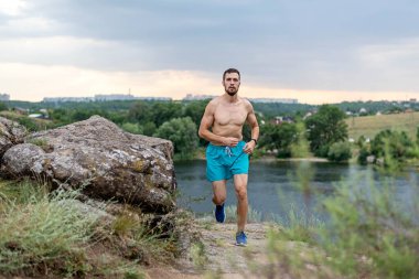 Taşların üzerinde koşan erkek koşucu, boş alanın kopyası. Aktif yaşam tarzı, atletizm.