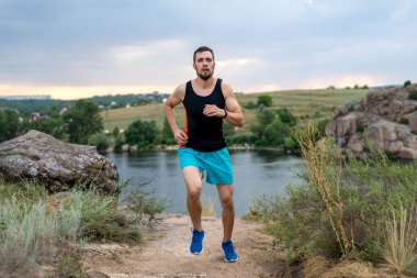 Taşların üzerinde koşan erkek koşucu, boş alanın kopyası. Aktif yaşam tarzı, atletizm.