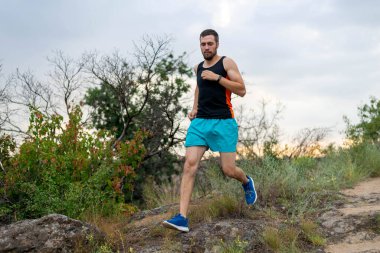 Taşların üzerinde koşan erkek koşucu, boş alanın kopyası. Aktif yaşam tarzı, atletizm.
