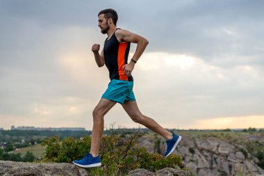 Taşların üzerinde koşan erkek koşucu, boş alanın kopyası. Aktif yaşam tarzı, atletizm.