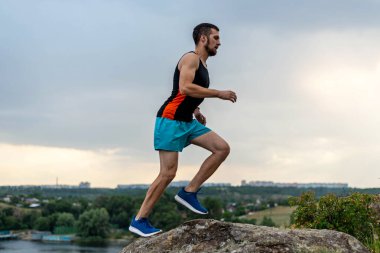 Taşların üzerinde koşan erkek koşucu, boş alanın kopyası. Aktif yaşam tarzı, atletizm.