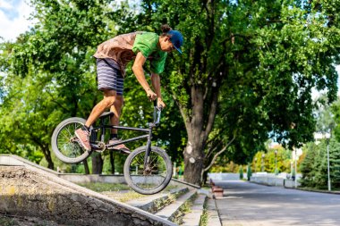 BMX bisikletçisi şehir merdivenlerinden bir numara yapıyor. Aşırı bisiklet sürme. Kentsel freeride.