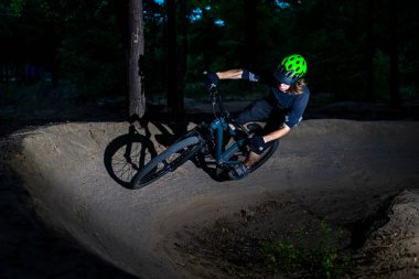 Bisikletçi gece vurgu yaparak keskin bir dönüş yapar. Aşırı bisiklet konsepti. Tehlike. Dağ bisikleti.
