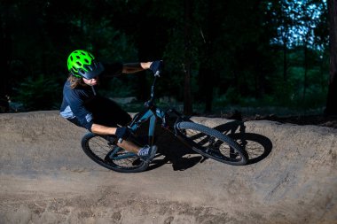 Bisikletçi gece vurgu yaparak keskin bir dönüş yapar. Aşırı bisiklet konsepti. Tehlike. Dağ bisikleti.