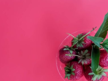 Pembe arka planda çilekler