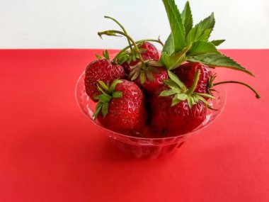 Kırmızı arka planda çilekler
