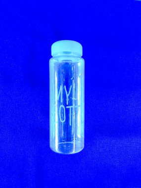 Mavi arka planda su olan şişe.