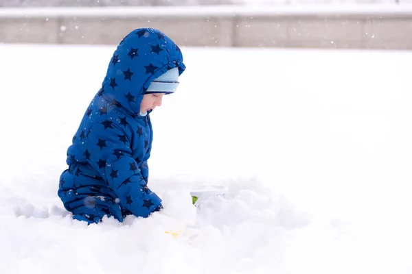 Niño, niño de tres años con ropa de invierno jugando con la nieve . —  Fotos de Stock