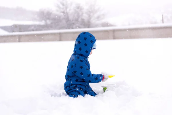 Child, three years old boy in winter clothes playing with snow. — Stock Photo, Image