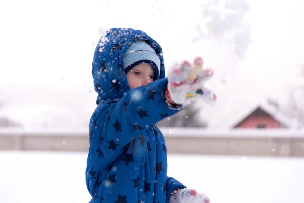 Child, three years old boy in winter clothes playing with snow. — Stock Photo, Image