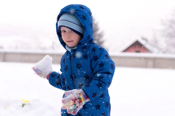 Child, three years old boy in winter clothes playing with snow. — Stock Photo, Image