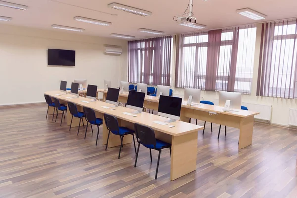 Oficina moderna con ordenadores en escritorios. Sala de ordenadores vacía en co — Foto de Stock