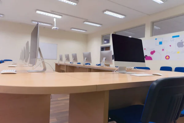 Oficina moderna con ordenadores en escritorios. Sala de ordenadores vacía en co — Foto de Stock