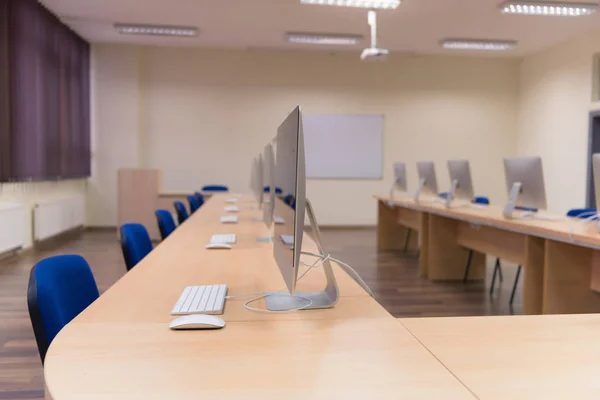 Oficina moderna con ordenadores en escritorios. Sala de ordenadores vacía en co — Foto de Stock