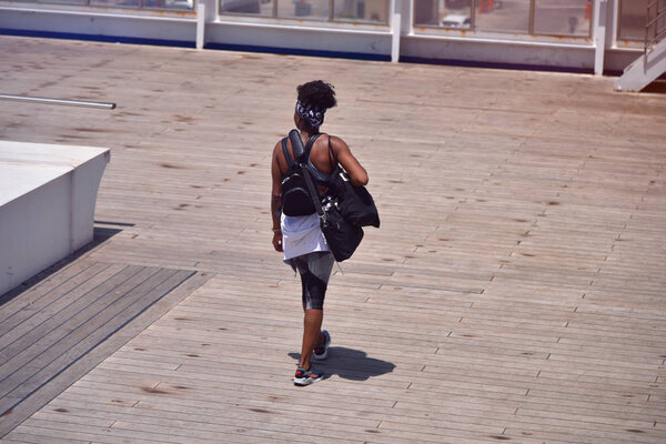 Молодая африканская спортсменка готовится к бегу. Молодая женщина собирается начать спринт, готовясь к бегу.