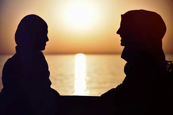 Silhouet van twee Moslimvrouwen in hijab staat op de pas — Stockfoto