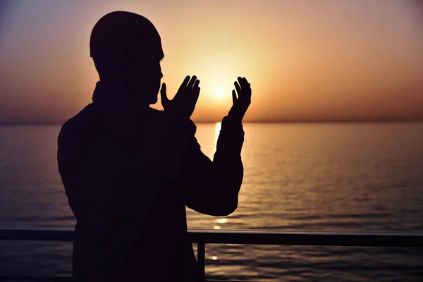 Muslimisches Gebet im Schiff, das bei Sonnenuntergang mit erhobenen Händen betet. a sil — Stockfoto