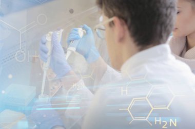 Laboratuvarda deney tüpleriyle çalışan iki genç bilim adamı...