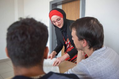 Bayan Müslüman profesör öğrencilere ders veriyor ve iletişim kuruyor. 