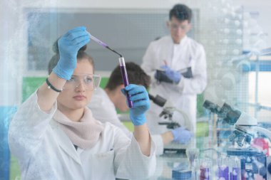 Laboratuvarda test tu ile çalışan bir grup genç bilim adamı.