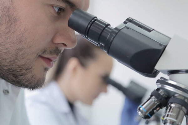 Two young Laboratory scientists working at lab with test tubes a