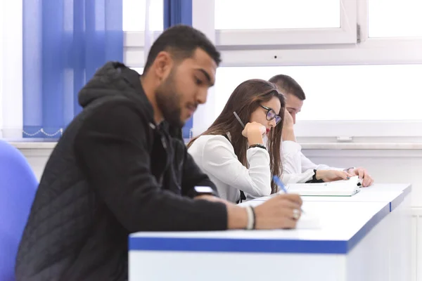 Universitaria estudiante en clase se sienta en su escritorio girando a s — Foto de Stock