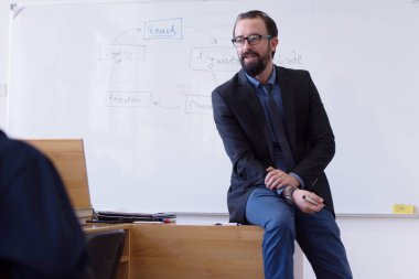 Modern okul sınıfında bir grup öğrenci profesörle birlikte okuyor.