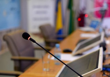 İş konfeksiyonu sırasında konferans salonunda mikrofonlar ve monitörler